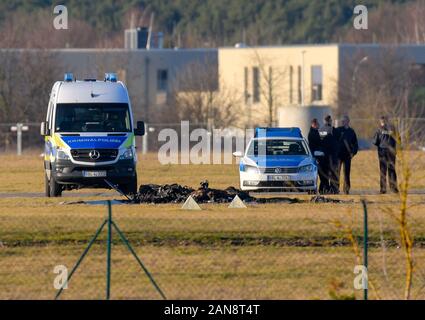 Strausberg, Deutschland. 16 Jan, 2020. Zwischen zwei Fahrzeuge der Polizei die verkohlten Überreste eines kleinen Flugzeug auf dem Gelände des Flugplatz Strausberg gesehen werden kann. Zwei Menschen starben beim Absturz eines Kleinflugzeugs auf dem Flugplatz in Strausberg, Brandenburg. Als die Feuerwehr am Donnerstag weiter mitteilte, wurden keine weiteren Verletzten. Warum das Flugzeug stürzte zunächst unklar blieb. Foto: Patrick Pleul/dpa-Zentralbild/dpa/Alamy leben Nachrichten Stockfoto