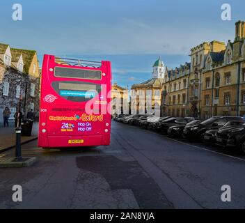 Hop-on Hop-off oben offenen Doppeldecker Stadt sehen Bus mit grellen Farben außerhalb der Hochschulen an der Universität von Oxford, England gemalt. Stockfoto