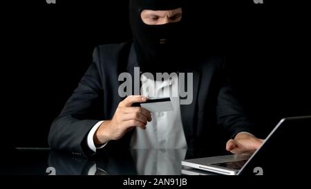 Mann in Balaclava und Klage begehen Bank Betrug, mit gestohlenen Kreditkarte, Kriminalität Stockfoto