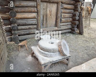 Rotary discoid Mill Stone für Hand- Schleifen einer Getreide zu Mehl. Mittelalterliche hand-driven Mühlstein mahlen Weizen. Die alten Quern Stein Hand Mühle mit Stockfoto