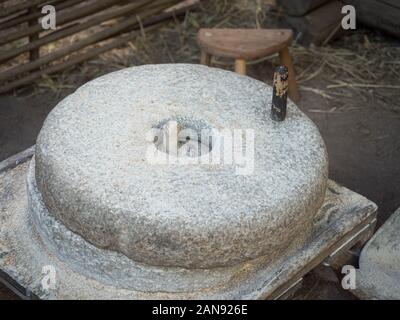 Rotary discoid Mill Stone für Hand- Schleifen einer Getreide zu Mehl. Mittelalterliche hand-driven Mühlstein mahlen Weizen. Die alten Quern Stein Hand Mühle mit Stockfoto