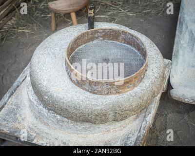 Rotary discoid Mill Stone für Hand- Schleifen einer Getreide zu Mehl. Mittelalterliche hand-driven Mühlstein mahlen Weizen. Die alten Quern Stein Hand Mühle mit Stockfoto