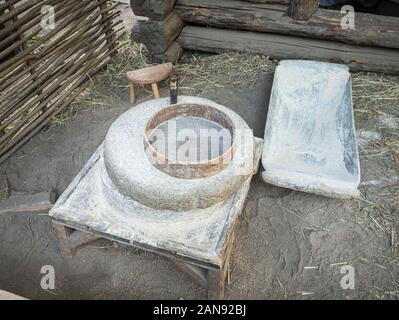 Rotary discoid Mill Stone für Hand- Schleifen einer Getreide zu Mehl. Mittelalterliche hand-driven Mühlstein mahlen Weizen. Die alten Quern Stein Hand Mühle mit Stockfoto