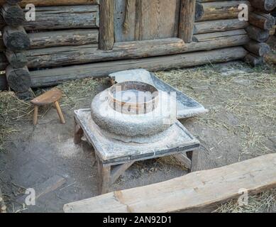 Rotary discoid Mill Stone für Hand- Schleifen einer Getreide zu Mehl. Mittelalterliche hand-driven Mühlstein mahlen Weizen. Die alten Quern Stein Hand Mühle mit Stockfoto