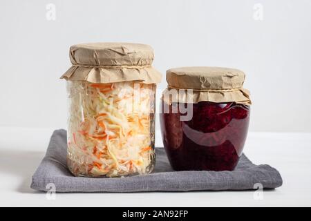 Hausgemachten Sauerkraut mit Karotten und Kohl Salat mit Rüben in einem Glas auf einem weißen Holz- Hintergrund. Fermentierter Lebensmittel. Stockfoto