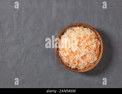 Hausgemachten Sauerkraut. Fermentierter Lebensmittel. Mit Karotten in einer Schüssel auf einem grauen Hintergrund Sauerkraut. Ansicht von oben, flach. Kopieren Sie Platz. Stockfoto