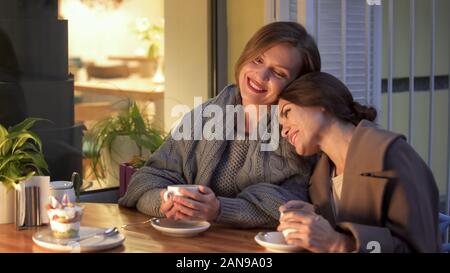 Zwei Schwestern im Cafe, holding Tassen Kaffee, gute Zeit zusammen in Stockfoto