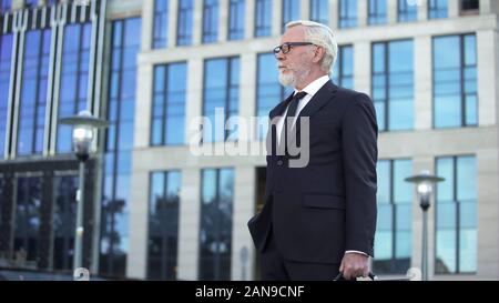 Grauhaarige Direktor des Unternehmens stehen im freien, selbstbewussten Unternehmer warten Stockfoto