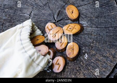 Holz- Runen in einem Canvas Tasche auf ein alter Baumstumpf Stockfoto