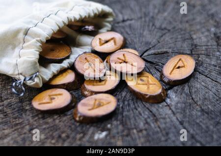 Holz- Runen in einem Canvas Tasche auf ein alter Baumstumpf Stockfoto