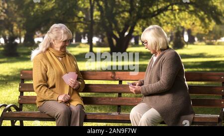 Zwei alte Freunde Karten Spiel, sitzt auf der Bank im Park, goldenen Jahre Stockfoto