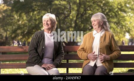 Zwei freudige älteren Frauen genießen Unternehmen der Passanten im Park, ältere Menschen Stockfoto