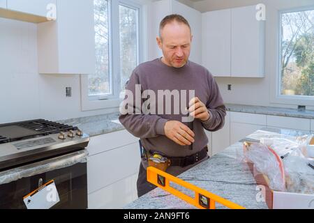 Klempner montiert installiert den Wasserhahn mit Leitungswasser. Stockfoto