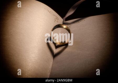 valentine Hearts,s valentine HertsGold Ehering Schatten macht valentine Herzen, auf einem alten Buch, warmes Licht gegossen goldenen Ring Schatten. valentinstag Stockfoto