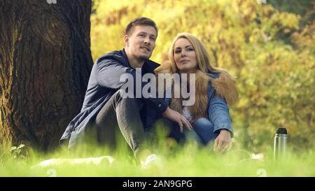 Paar sitzen unter Baum, in dem im Freien, ein Picknick im Park Glück Stockfoto