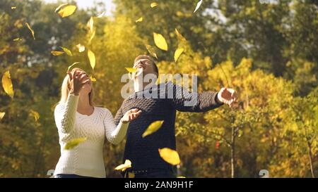 Freundliche Paar werfen Blätter im Herbst, Spaß, Zeit miteinander zu verbringen Stockfoto