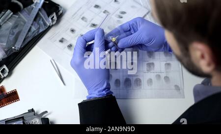 Kriminelle expert Prüfung bullet im Büro Tisch, Beweise in Kunststoffgehäuse Stockfoto