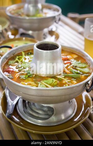 Tom Yum Suppe in traditionellen Geschirr in einem Street Restaurant Stockfoto