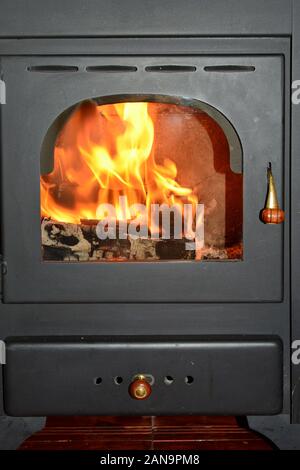 Alten Holzofen mit Brennholz im Inneren brennen, Ansicht schließen Stockfoto