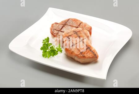 Zwei Rindersteaks auf Platte, grauer Hintergrund Stockfoto