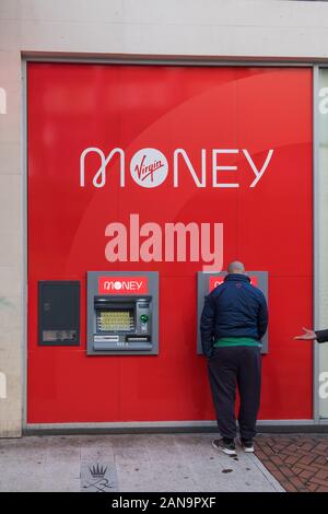 Man verwendet Cashpoint oder Geldautomaten außerhalb der neuen Virgin Money Bank Filiale in New Street, Birmingham, West Midlands, Großbritannien Stockfoto