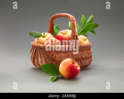 Korb der rote Äpfel auf grauem Hintergrund Stockfoto