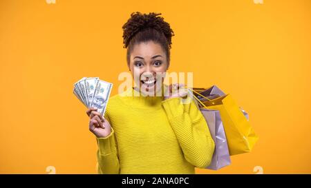 Emotionale Black Lady holding Bündel von Dollar und Einkaufstaschen, cash back Stockfoto