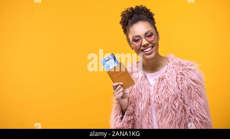 Ziemlich weiblich Holding Passport mit Tickets auf hellen Hintergrund, Abenteuer Stockfoto