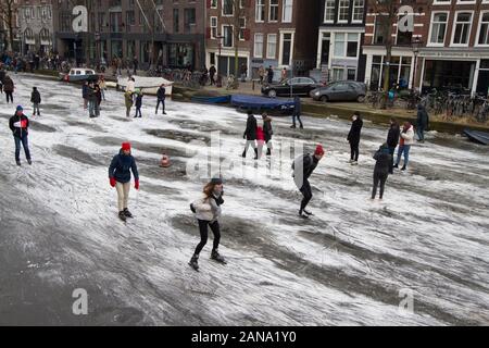 Menschen Schlittschuhlaufen auf zugefrorenen Grachten von Amsterdam im Winter 2018. Stockfoto