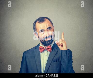 Geschäftsmann nach oben zeigt einen Zeigefinger, die Nummer eins, obere Richtung schauen Sie hier über dem Kopf Geste. Gemischte Rasse bearded Modell auf isolierte Stockfoto