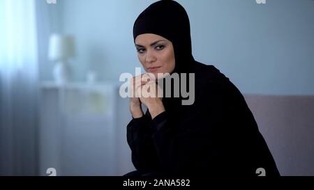 Traurig arabischen Frauen in Schwarz hijab zu Hause sitzen und denken leben Fehler, Krise Stockfoto