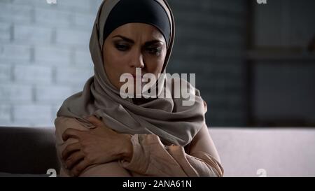 Verärgert arabische Frau im hijab Holding schmerzlich Hand, Angriff in Familie, soziales Problem Stockfoto