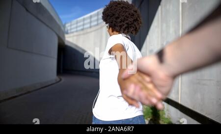 POV von Freund folgenden schönen Curly behaarte Frau, ihre Hand halten, Liebe Stockfoto