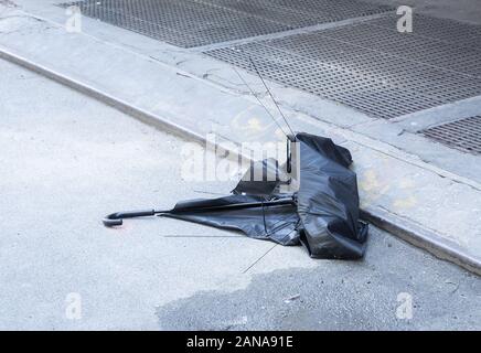 Eine verlassene, gebrochen Sonnenschirm auf einer Straße zu bändigen. Stockfoto