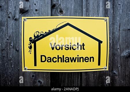 Warnschild mit einer einfachen Zeichnung eines Hauses und einem Dach, Lawine, deutsche Beschriftung Vorsicht Dachlawinen in Englisch sorgfältige Dach Lawine werden Stockfoto