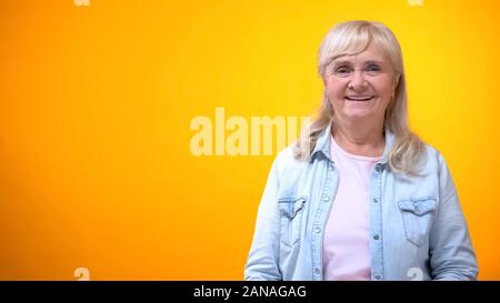 Alte Dame Lachen auf hellen Hintergrund, Gefühl gesund und finanziell abgesichert Stockfoto