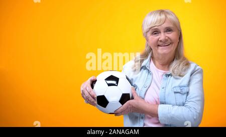 Fröhlicher Rentner Frau mit Fußball-ball, Sportwetten, positive Einstellung Stockfoto