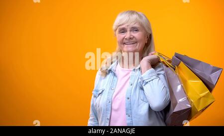 Lächelnd älteren weiblichen Holding Einkaufstaschen, angenehme Freizeit, Schwarzer Freitag Stockfoto