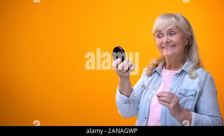 Schöne alte Frau im Spiegel zu betrachten, Make-up, Kosmetik für Rentner Stockfoto
