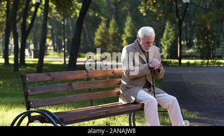 Lonely umgekippt alte Mann allein sitzt im Park und denken über das Leben, Rentner Stockfoto