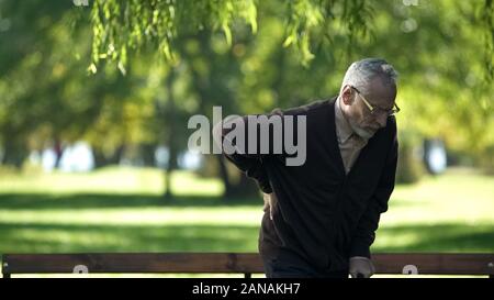 Ältere männliche stehen von Bank, Gefühl, Schmerz im Rücken, gesundheitliche Probleme Stockfoto