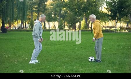 Ältere Sportler Fußball spielen, am Wochenende im Park, aktive Freizeitgestaltung, Freundschaft Stockfoto