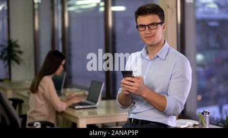 Junge schöne Büro suchen Kamera mit Smartphone Hände, Anwendung Stockfoto