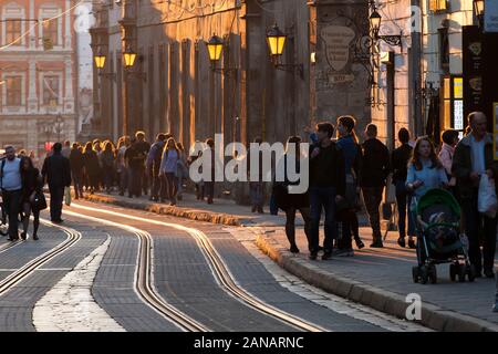 Ukrainische Pendler Spaziergang entlang der Straßenbahn-Linien der alten Stadt in der Dämmerung in Lemberg, Ukraine. Stockfoto