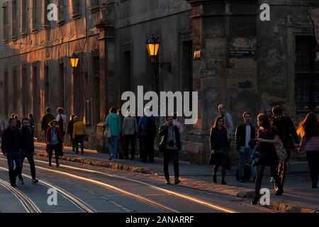 Ukrainische Pendler Spaziergang entlang der Straßenbahn-Linien der alten Stadt in der Dämmerung in Lemberg, Ukraine. Stockfoto