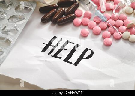 Wort 'Hilfe' in der Haufen von Pillen, Tabletten und Spritzen. Konzept der Drogenmissbrauch, Überdosis oder illegale Drogen dependancy Stockfoto