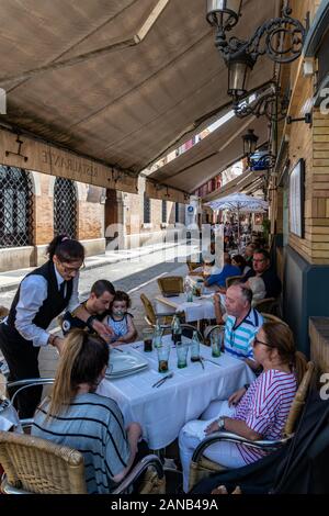 Familien, die Sonntags-Mittagessen an einem warmen Herbstnachmittag in der historischen Bar Victoria Eugenia und im Restaurant Calle Cuna in Sevilla genießen Stockfoto