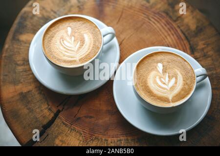 Zwei Tassen aromatischen Kaffee Cappuccino oder Latte auf einer hölzernen Tisch. Lecker morgen Getränke. Stockfoto