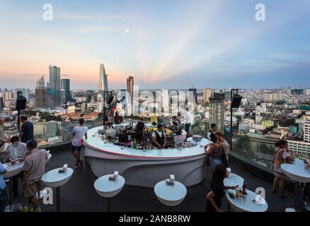 Ho Chi Minh City, Vietnam - am 17. März 2018: Touristen genießen Sie einen Drink an der Bar auf der Dachterrasse über den Saigon Skyline bei Sonnenuntergang in Vietnam, die größte Stadt in So Stockfoto