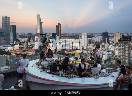 Ho Chi Minh City, Vietnam - am 17. März 2018: Touristen genießen Sie einen Drink an der Bar auf der Dachterrasse über den Saigon Skyline bei Sonnenuntergang in Vietnam, die größte Stadt in So Stockfoto